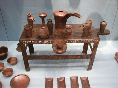 Equipo ritual en miniatura del sacerdote-lector Ibi. En la hilera posterior de objetos, entre las dos jofainas, a la izquierda, puede verse un incensario del Tipo V. Fines de la Sexta Dinastía (tempus Pepi II). Museo Británico de Londres