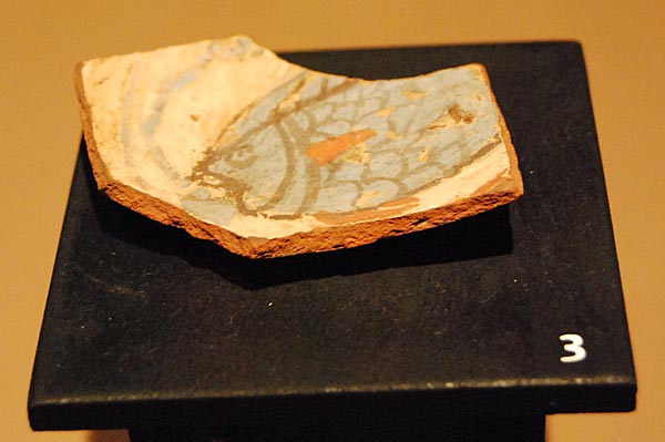 Fragmento de cerámica decorada con un pez y flores de loto